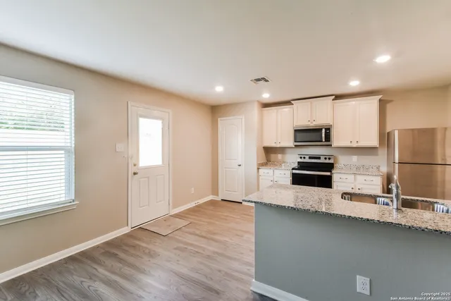 a kitchen with stainless steel appliances a refrigerator sink and microwave