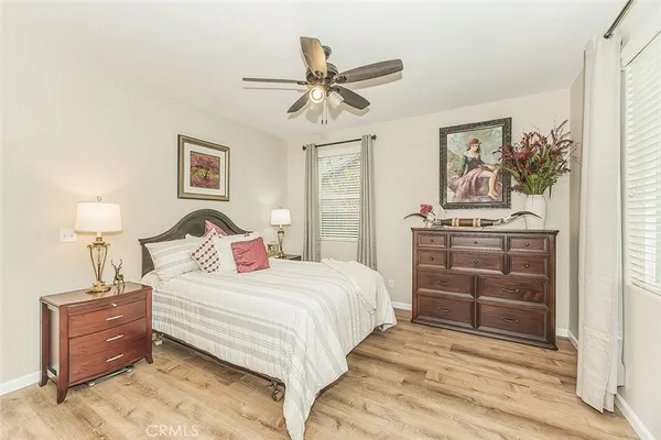 a bedroom with a bed lamp and paintings on the wall