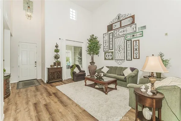 a living room with furniture and a dining table with wooden floor