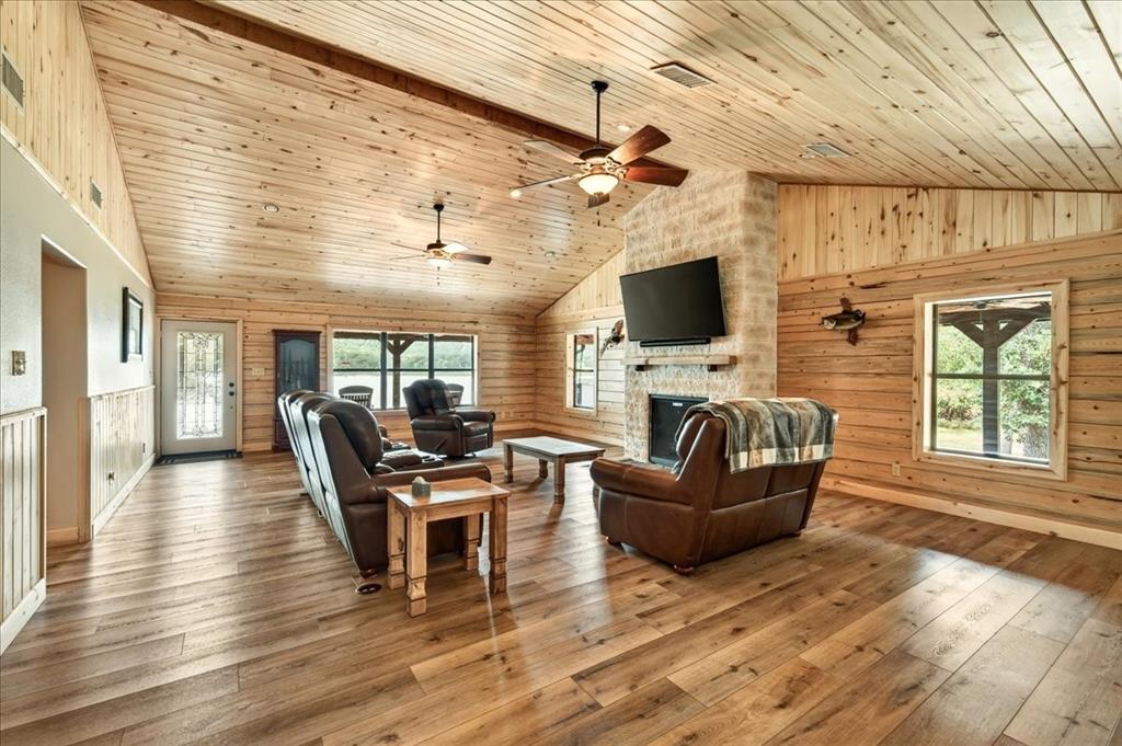 Vaulted wood-finish ceiling, wood-finish flooring, stone-clad fireplace, built-in fireplace mantel, and recessed lighting