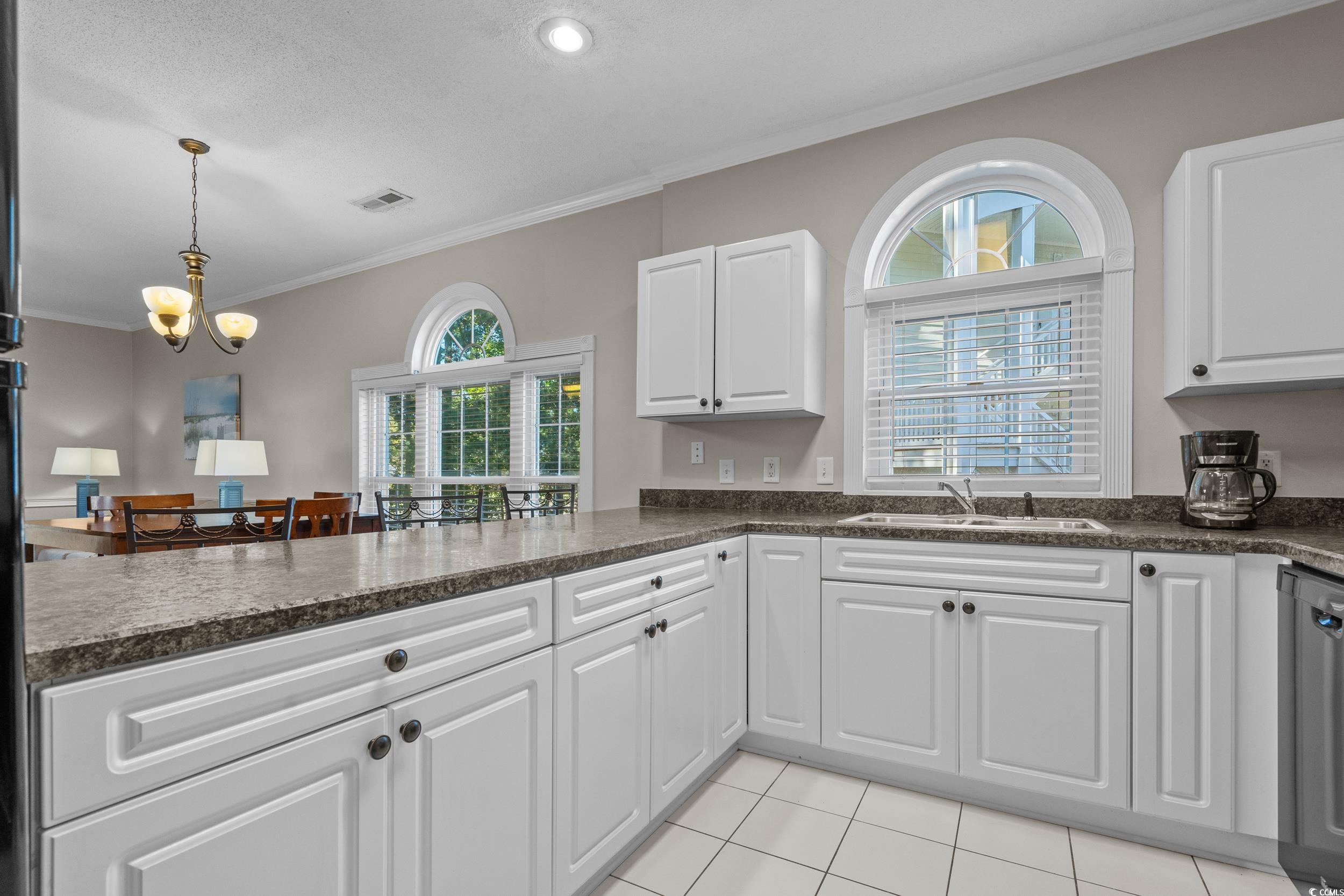 686 Riverwalk Drive, Unit 204 Myrtle Beach, SC 29579 - Photo 13 of 40 Kitchen featuring crown molding, white cabinets, plenty of natural light, light tile patterned floors, and recessed lighting