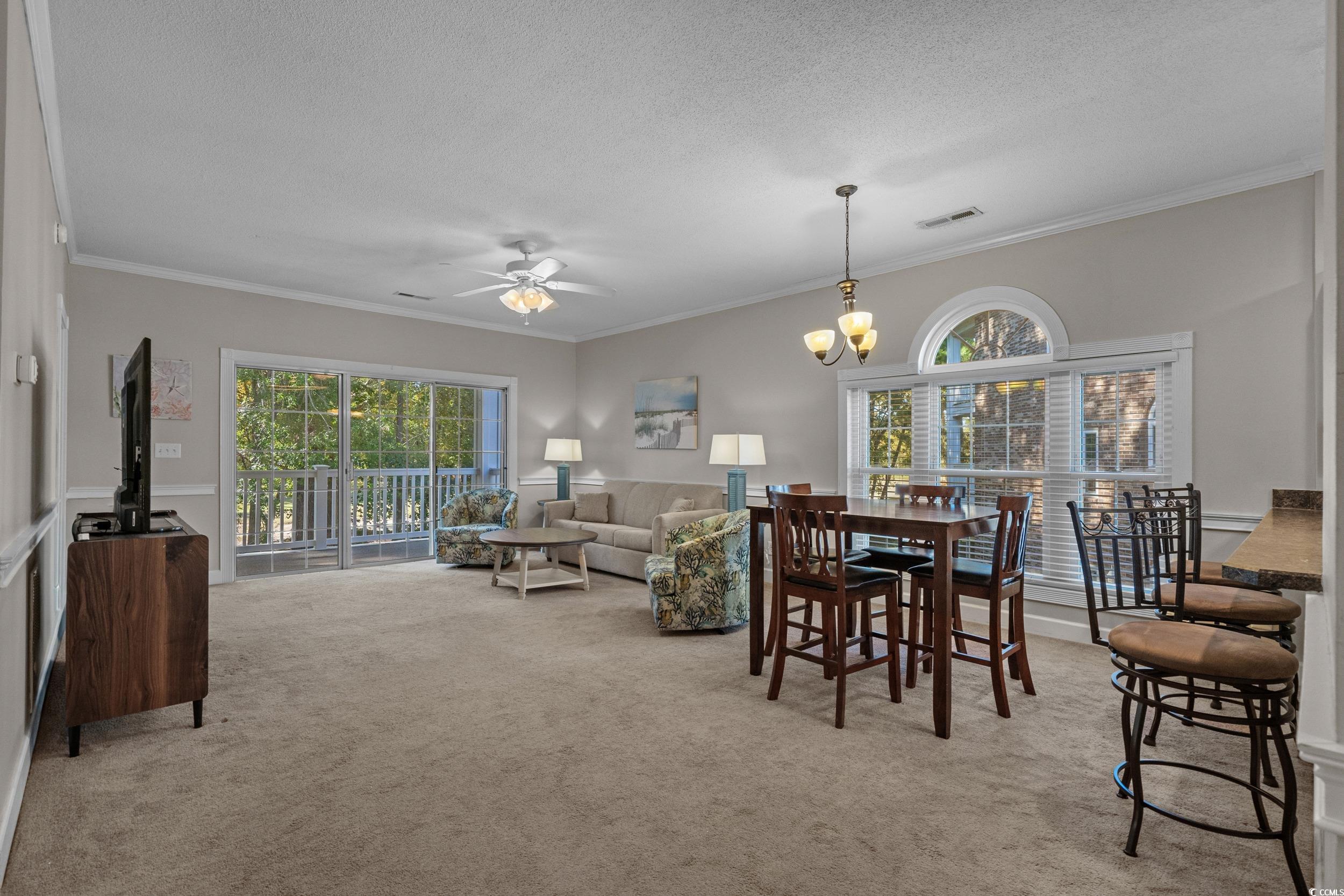 686 Riverwalk Drive, Unit 204 Myrtle Beach, SC 29579 - Photo 5 of 40 Dining room with ornamental molding, light colored carpet, ceiling fan, a textured ceiling, and a chandelier
