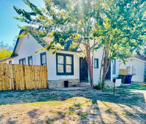 a front view of house with yard and trees in the background