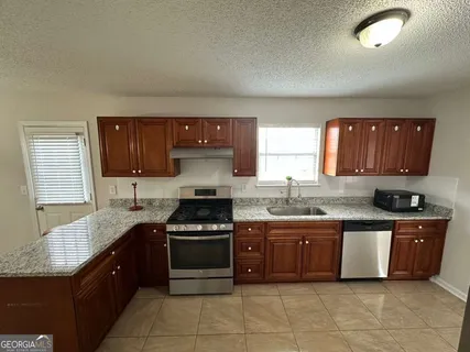 a kitchen with stainless steel appliances granite countertop a stove sink and cabinets