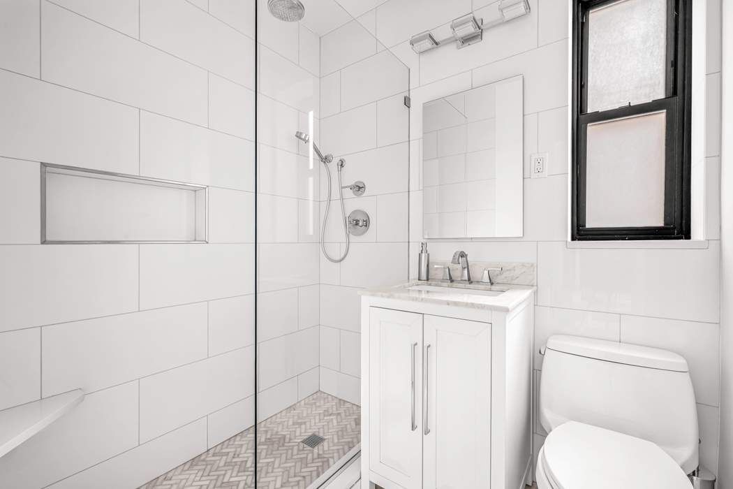 225 East 74th Street, Unit 2M Manhattan, NY 10021 - Photo 8 of 16 a bathroom with a sink a toilet and shower