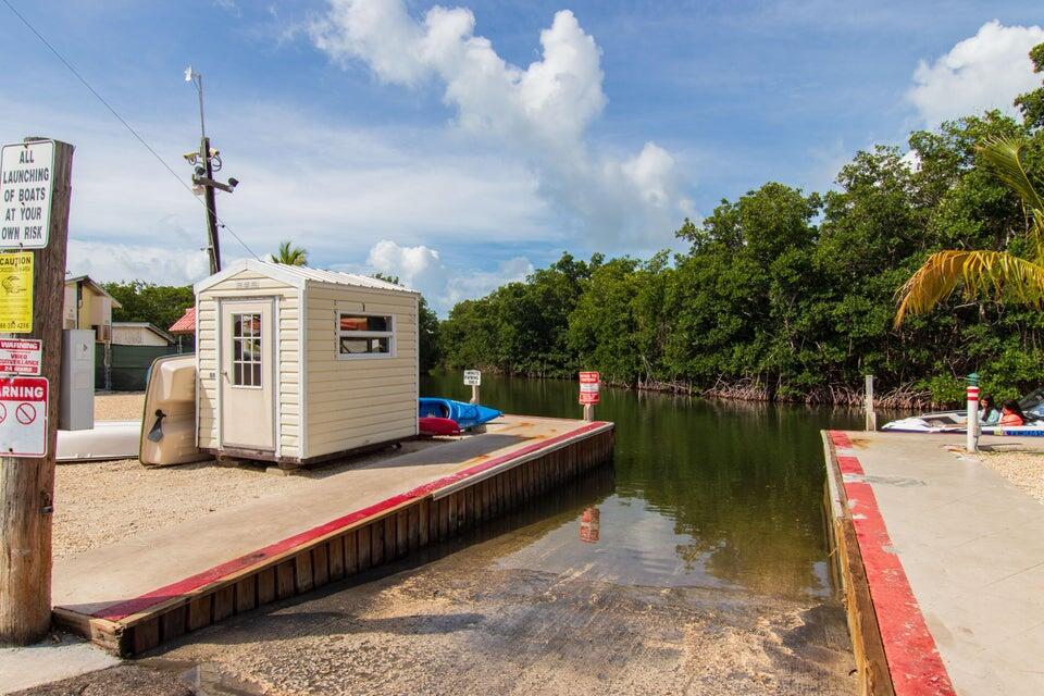 325 Calusa Street, Unit 413 Key Largo, FL 33037 - Photo 24 of 27 a utility room with large trees and cars parked