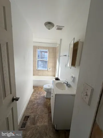 a bathroom with a toilet a sink and mirror