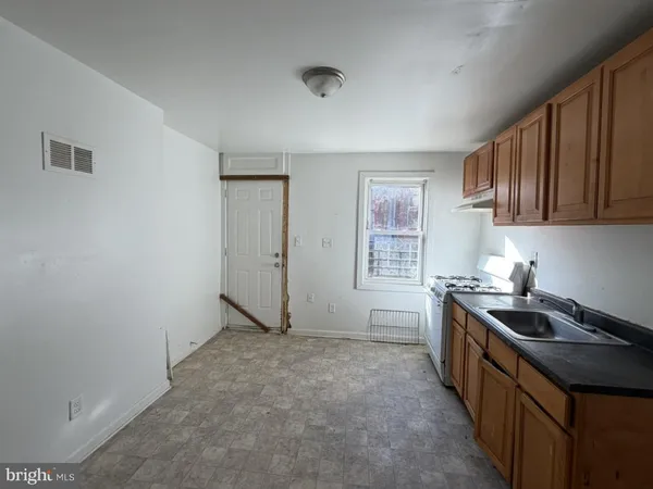 a kitchen with stainless steel appliances granite countertop a stove a sink and a refrigerator