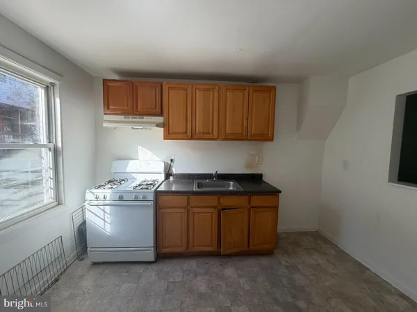 a kitchen with granite countertop a sink and a stove top oven