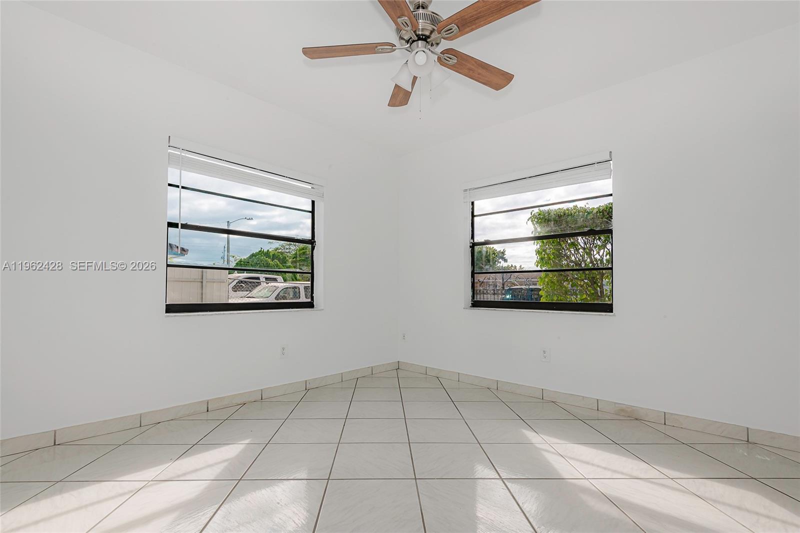 11941 Southwest 178th Terrace Miami, FL 33177 - Photo 16 of 33 a view of an empty room with wooden floor and a window