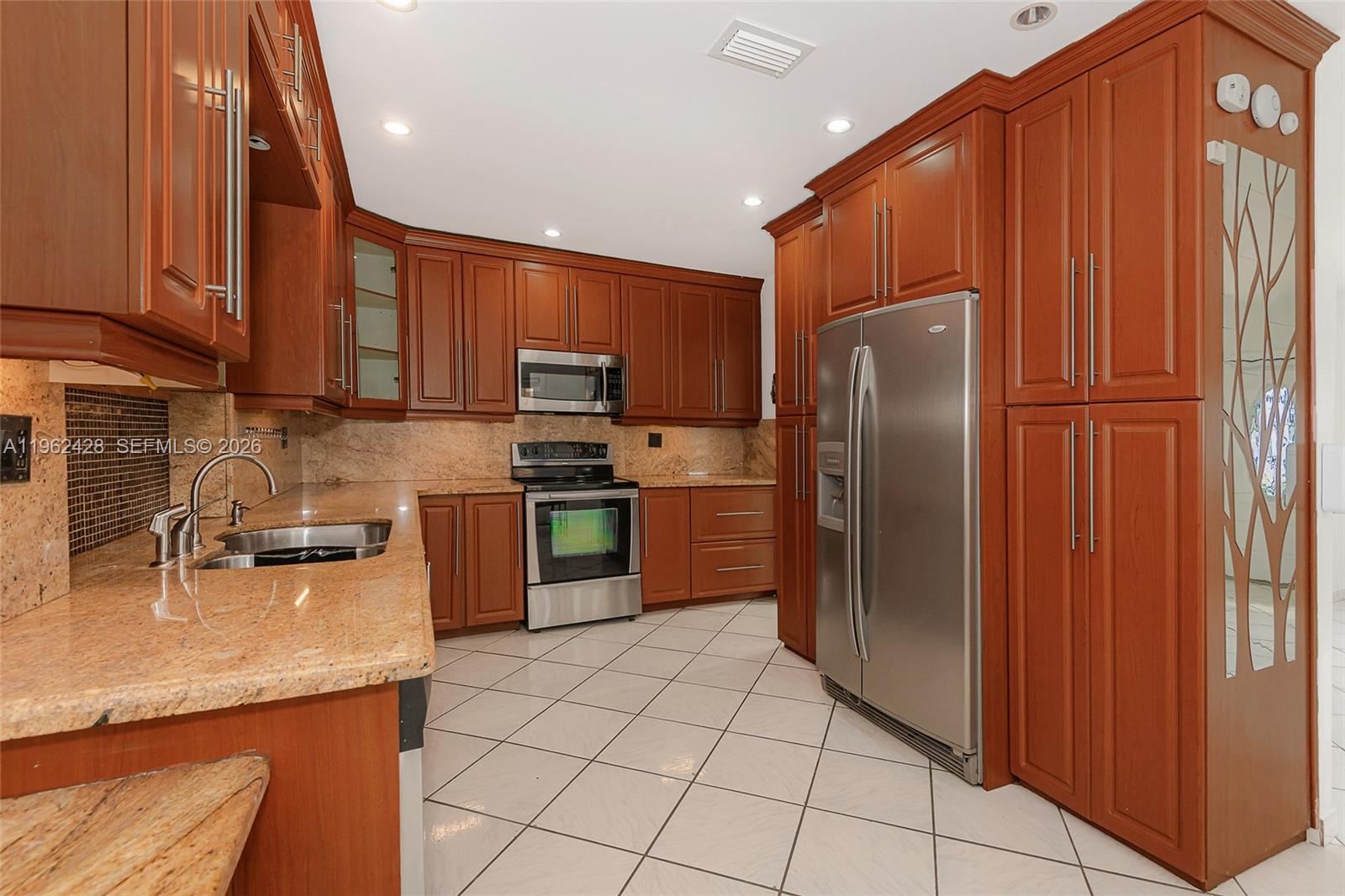 11941 Southwest 178th Terrace Miami, FL 33177 - Photo 10 of 33 a kitchen with stainless steel appliances granite countertop a refrigerator and a sink