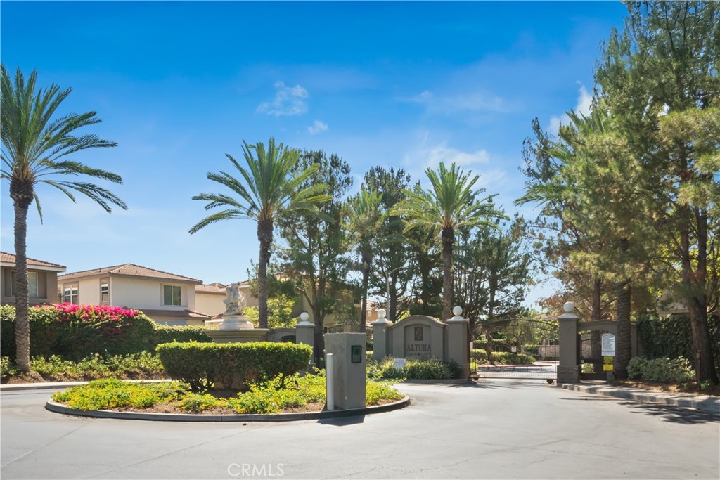 a front view of a house with a yard and fountain in middle