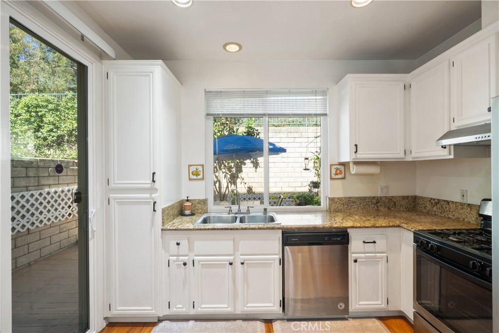 1517 Ismail Place Placentia, CA 92870 - Photo 7 of 28 a kitchen with stainless steel appliances granite countertop a stove a sink and a granite counter tops with white cabinets