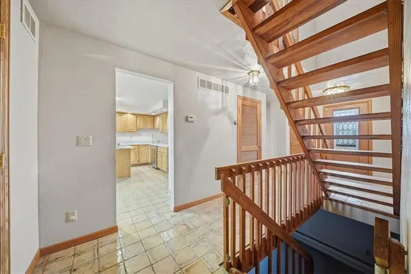 a view of staircase with lots of frames on wall and a large window