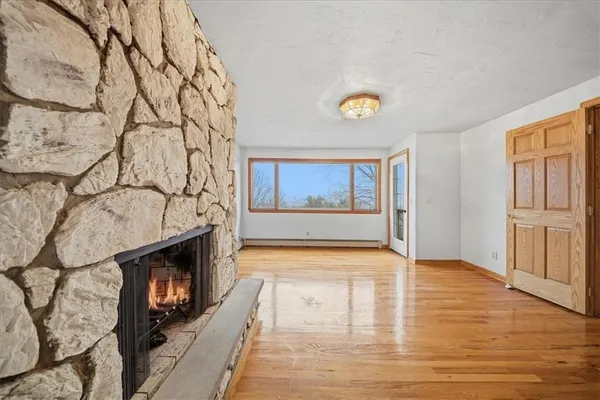 a view of an empty room with a fireplace and a window