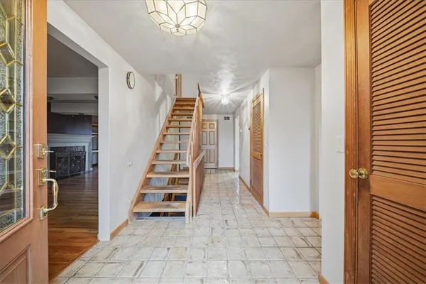 a view of a hallway with entryway wooden floor and staircase
