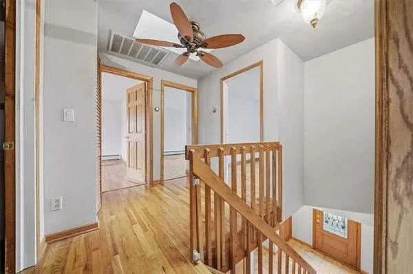 a view of a hallway with wooden floor and staircase