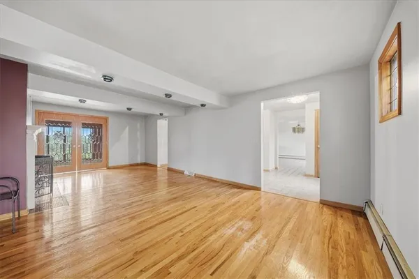 a view of empty room with wooden floor and fan