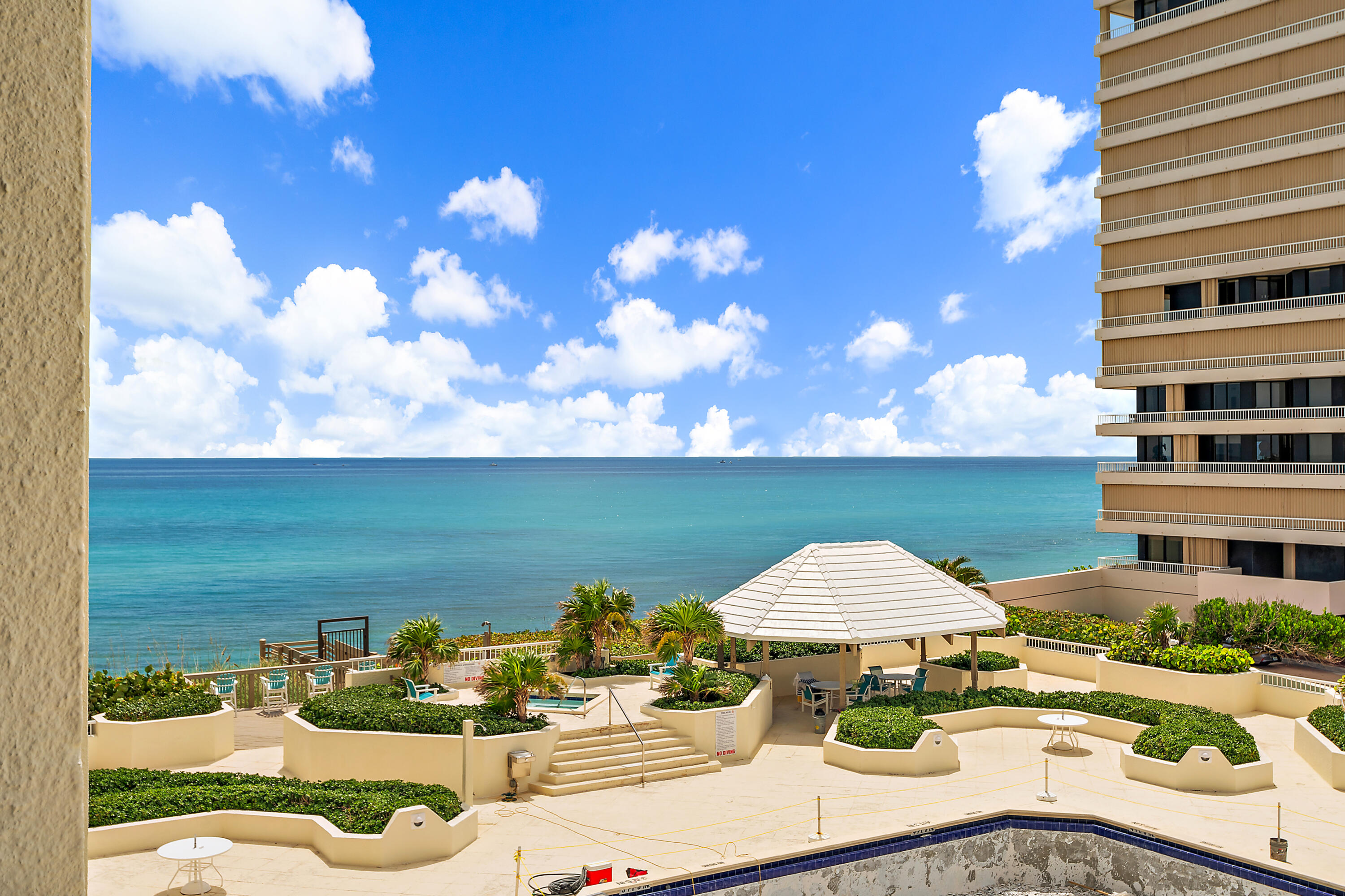 5280 North Ocean Drive, Unit 2F Singer Island, FL 33404 - Photo 21 of 92 a front view of a house with a yard and seating area