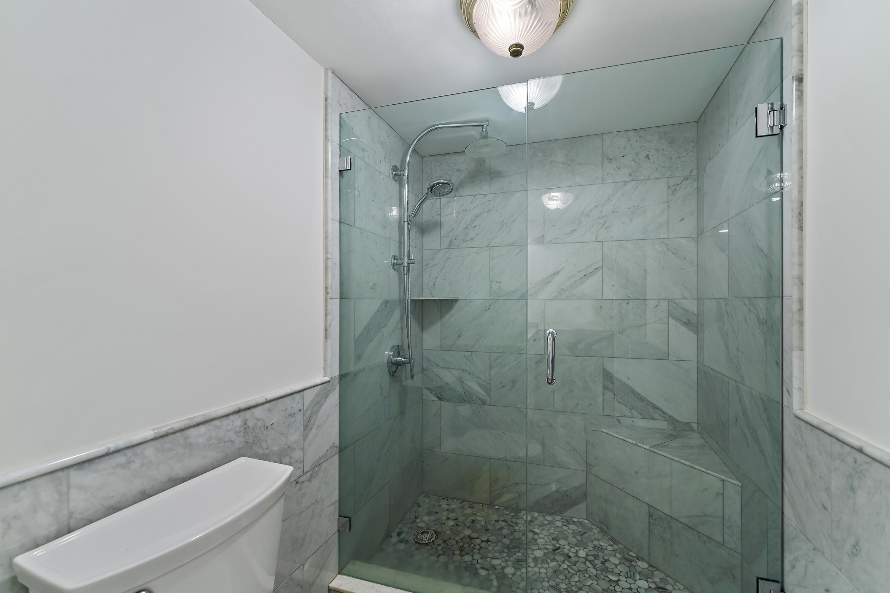 5280 North Ocean Drive, Unit 2F Singer Island, FL 33404 - Photo 35 of 92 a bathroom with a shower a toilet and a sink