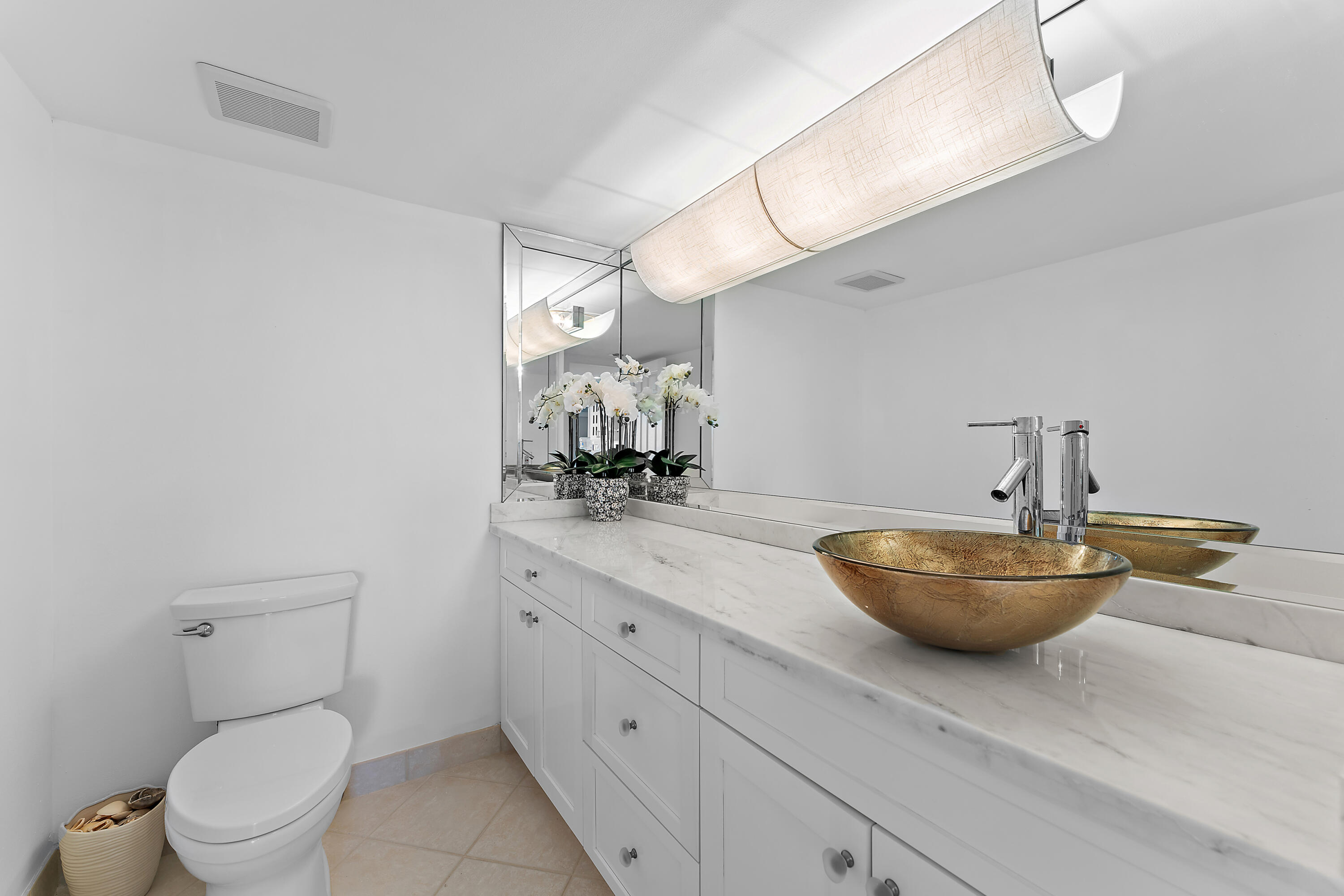 5280 North Ocean Drive, Unit 2F Singer Island, FL 33404 - Photo 39 of 92 a bathroom with a toilet a sink and a mirror