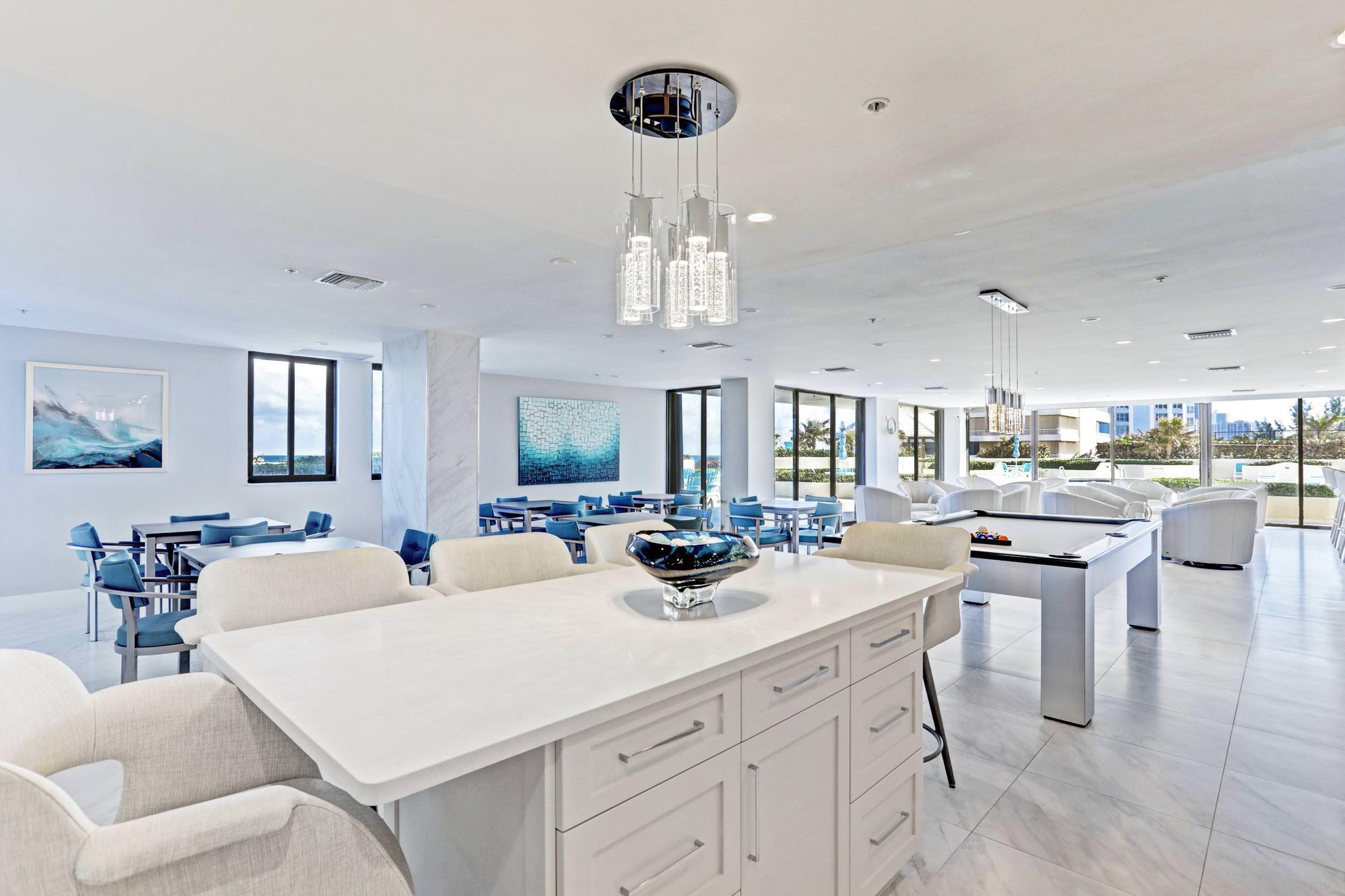 5280 North Ocean Drive, Unit 2F Singer Island, FL 33404 - Photo 53 of 92 a kitchen with stainless steel appliances kitchen island granite countertop a table chairs and a chandelier
