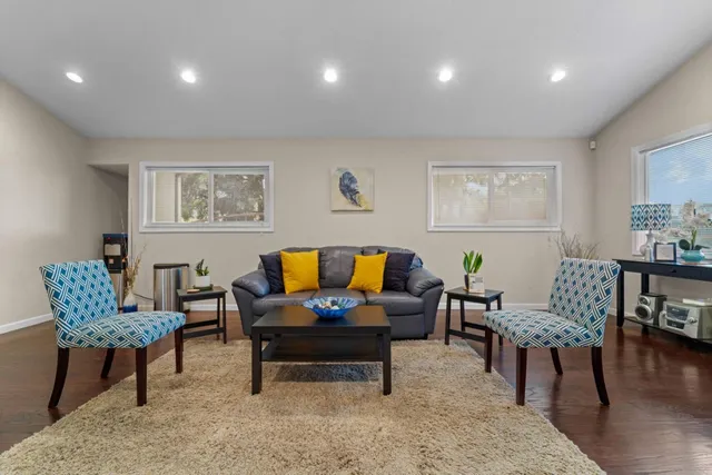 a living room with furniture and a wooden floor