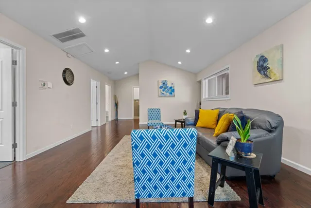 a living room with furniture and wooden floor