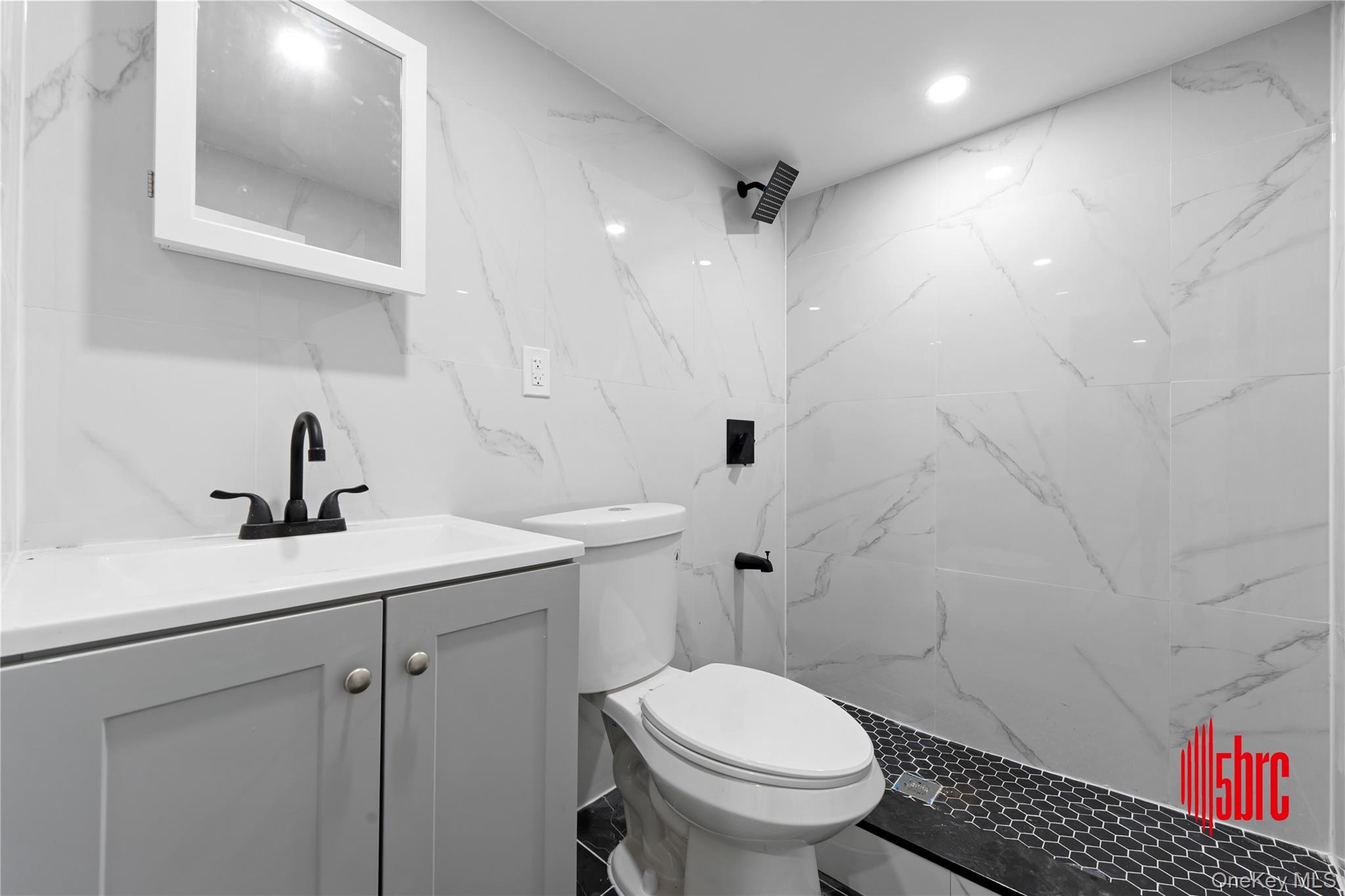 217-39 114th Road Queens, NY 11411 - Photo 17 of 23 Bathroom with vanity, a marble finish shower, and recessed lighting