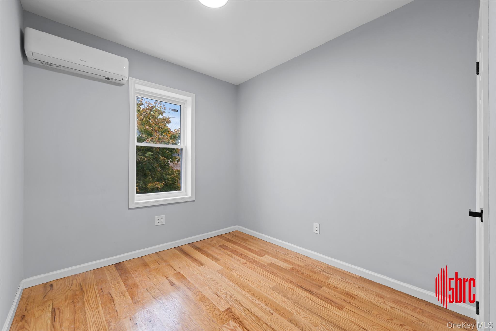 217-39 114th Road Queens, NY 11411 - Photo 8 of 23 Unfurnished room featuring an AC wall unit and light wood finished floors