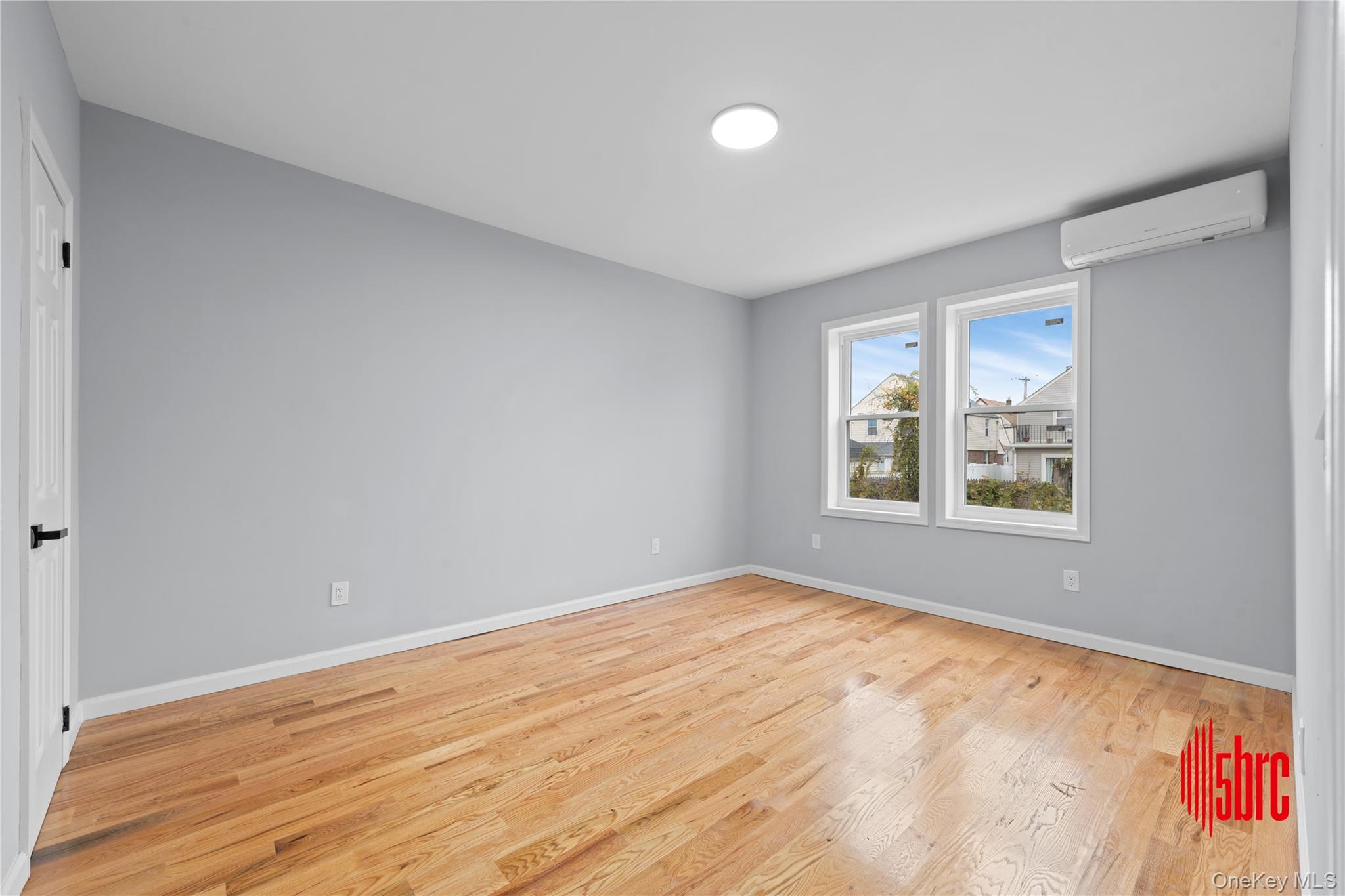 217-39 114th Road Queens, NY 11411 - Photo 9 of 23 Spare room featuring light wood finished floors and a wall mounted air conditioner