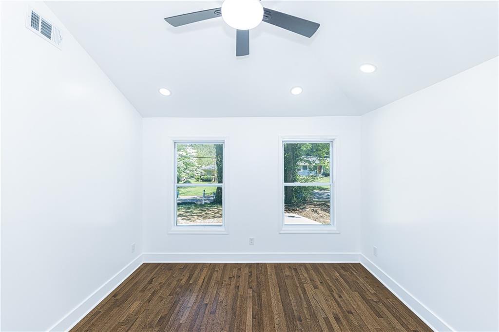 3013 Catalina Drive Decatur, GA 30032 - Photo 14 of 48 an empty room with wooden floor a ceiling fan and windows