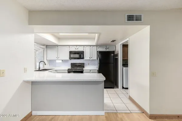 a kitchen with stainless steel appliances a refrigerator sink and microwave