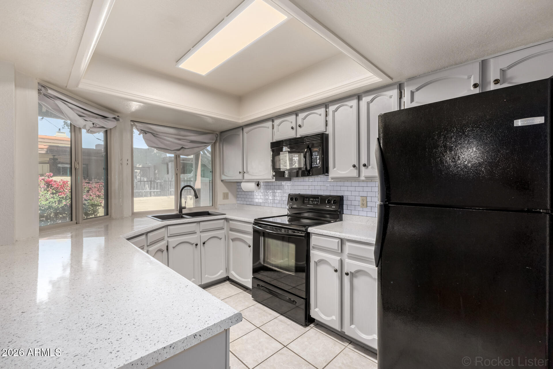 3004 West Phelps Road Phoenix, AZ 85053 - Photo 13 of 34 a kitchen with white cabinets and stainless steel appliances