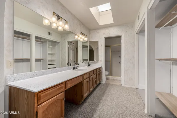 a spacious bathroom with a sink a large mirror and a shower