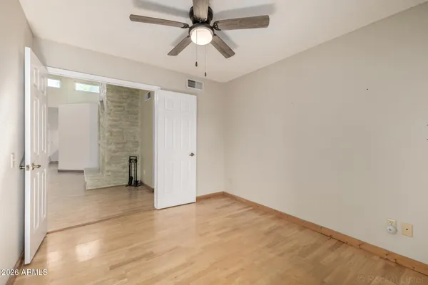 an empty room with closet and a ceiling fan