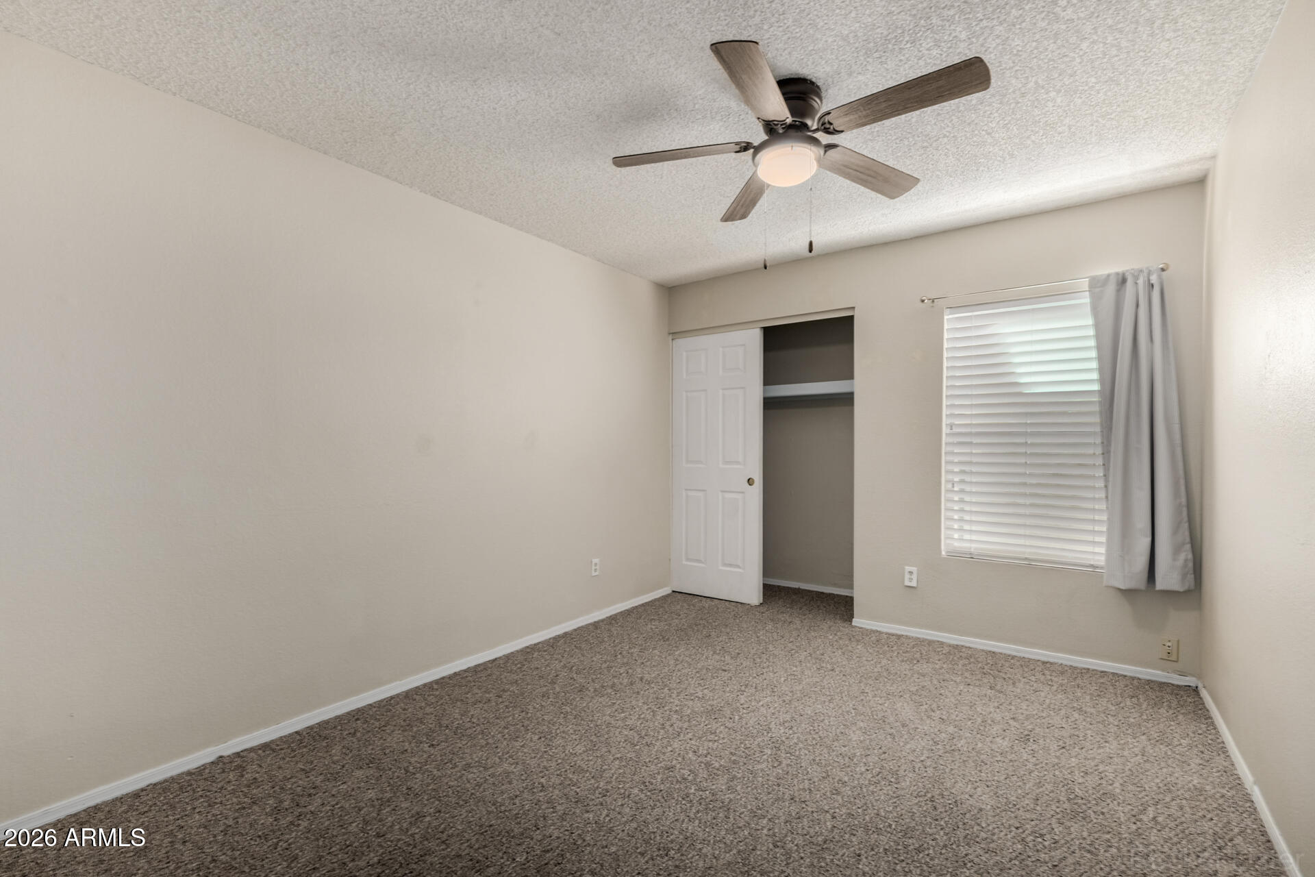3004 West Phelps Road Phoenix, AZ 85053 - Photo 25 of 34 an empty room with ceiling fan and window