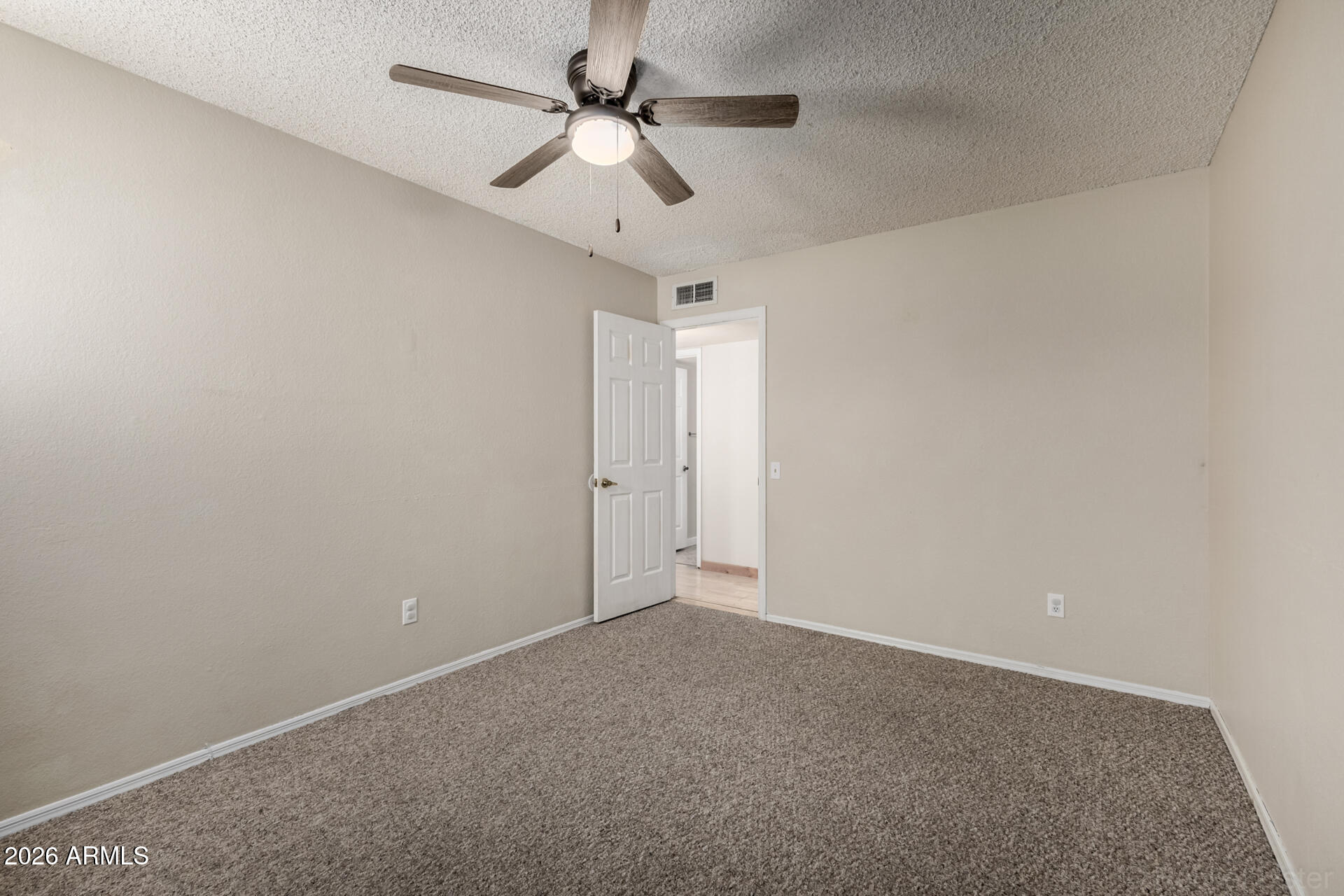 3004 West Phelps Road Phoenix, AZ 85053 - Photo 26 of 34 an empty room with a ceiling fan and a fan