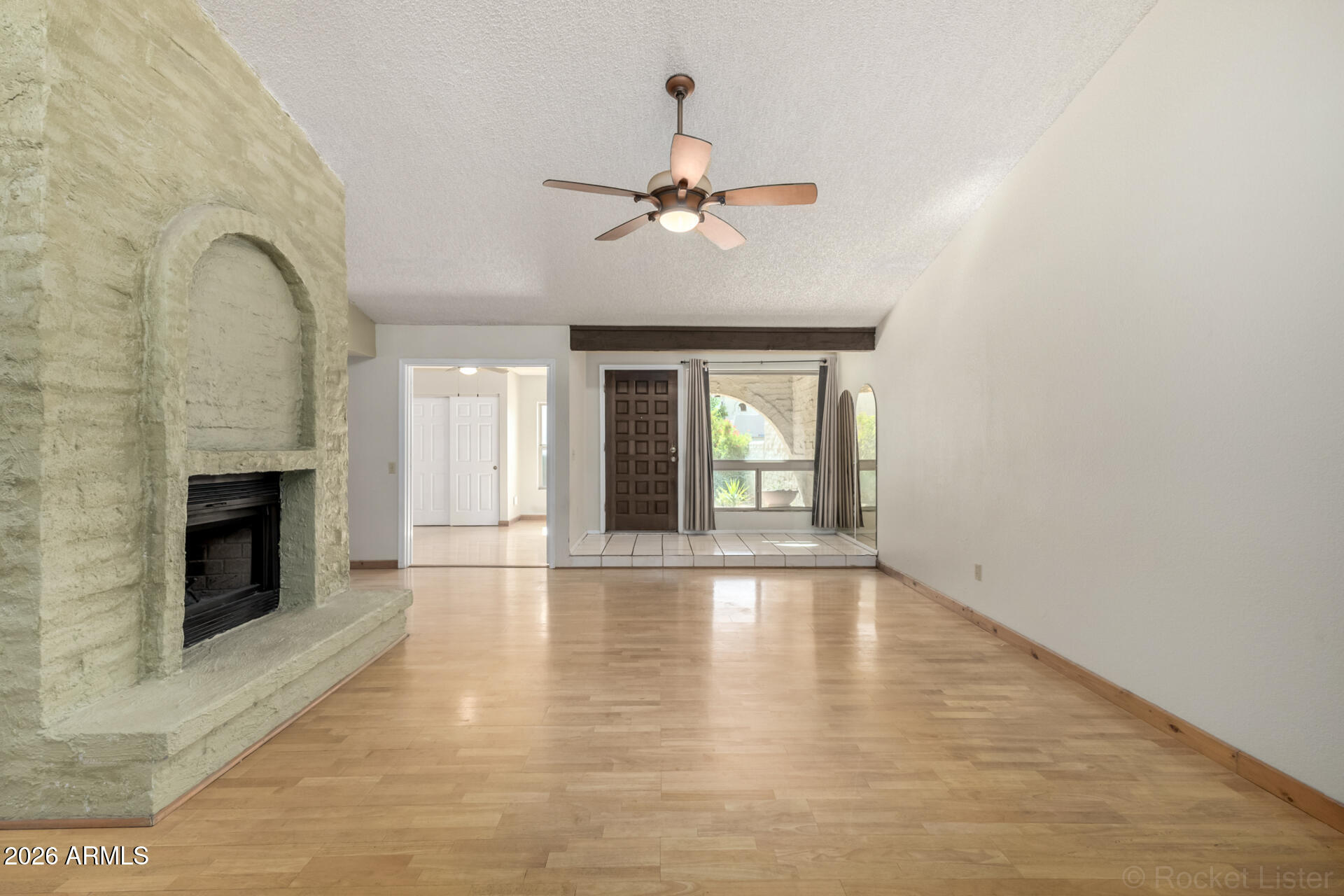 3004 West Phelps Road Phoenix, AZ 85053 - Photo 9 of 34 a view of an empty room with chandelier fan and fire place