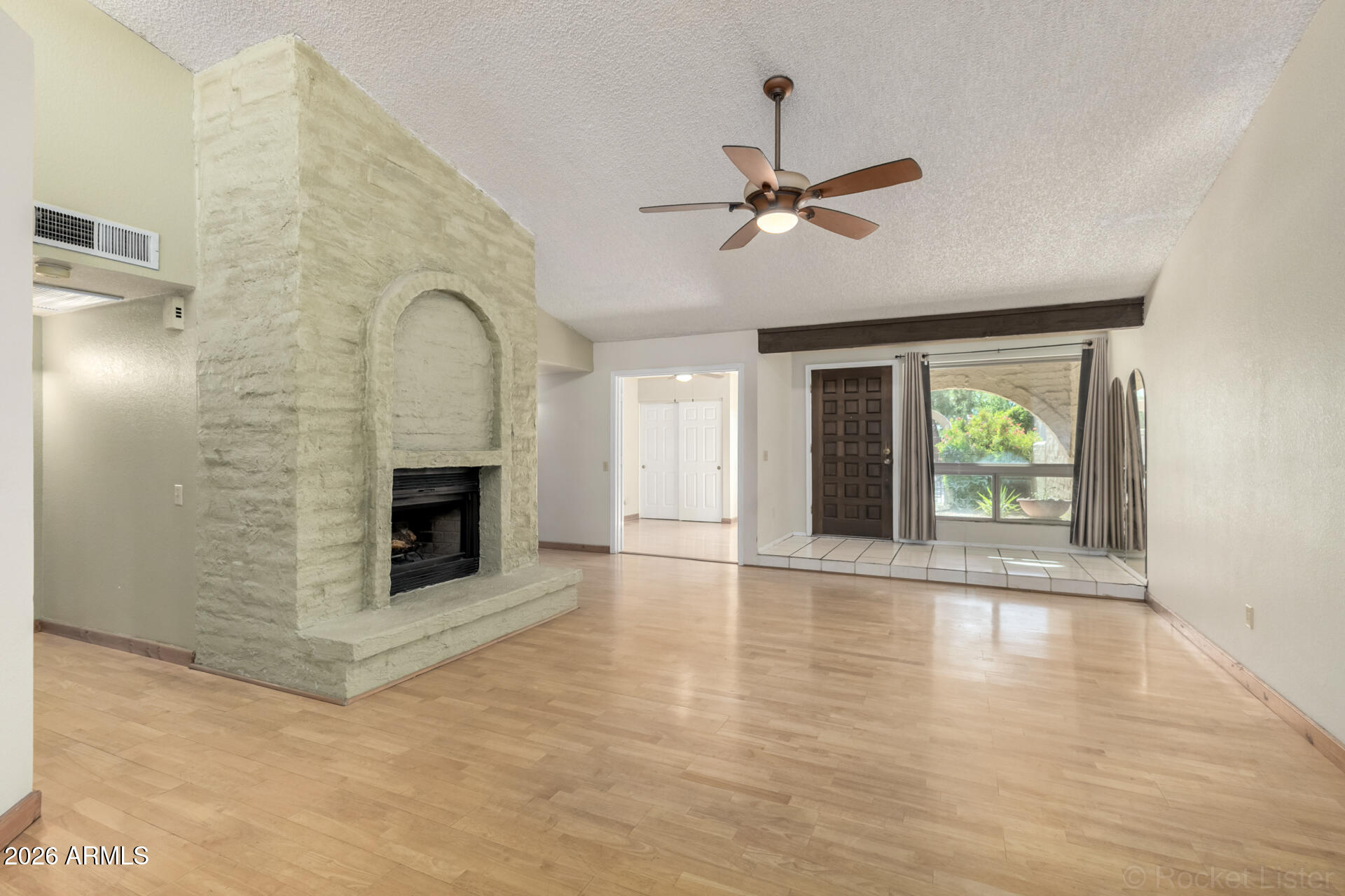 3004 West Phelps Road Phoenix, AZ 85053 - Photo 10 of 34 a view of empty room with fireplace and wooden floor