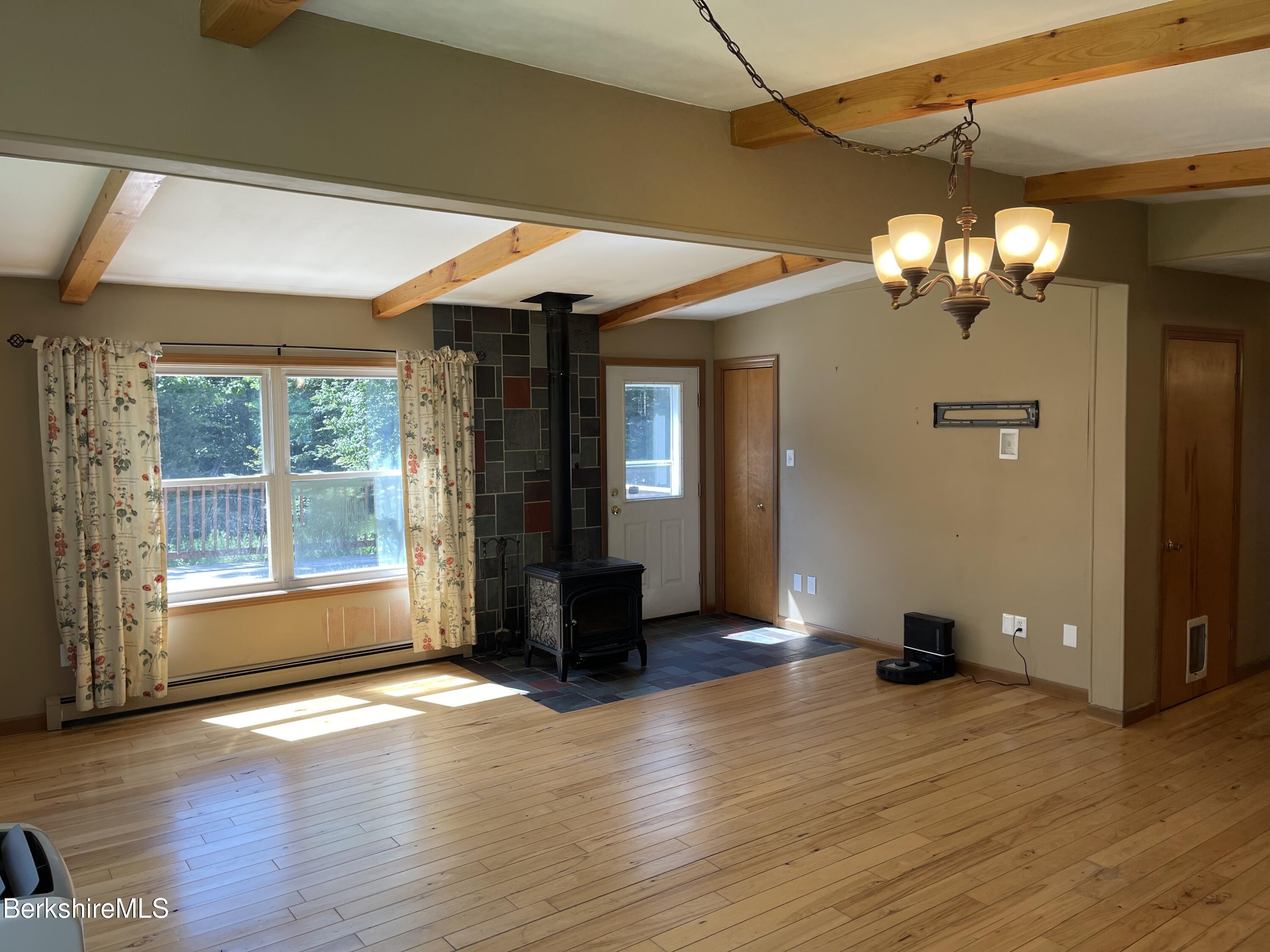 604 Loop Road Savoy, MA 01256 - Photo 6 of 23 an empty room with wooden floor and windows