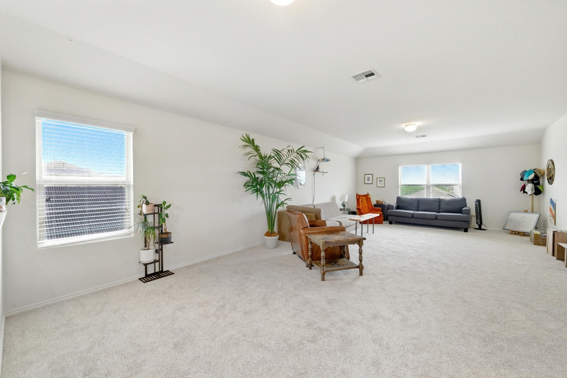3905 Alpine Autumn Drive Austin, TX 78744 - Photo 12 of 24 Living room featuring baseboards, carpet, and visible vents