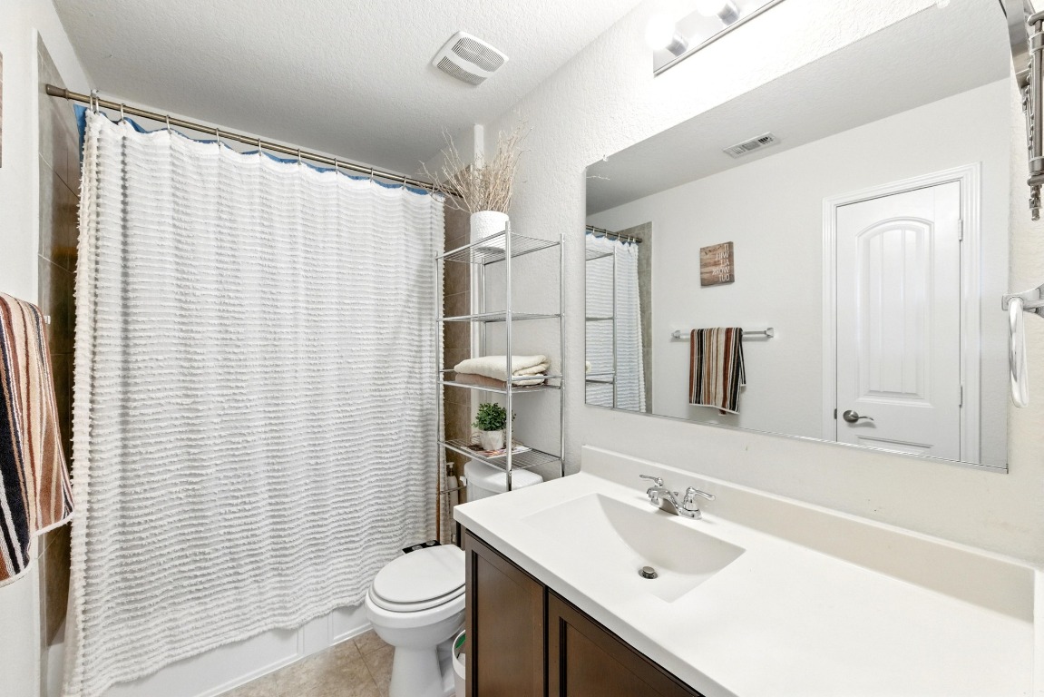3905 Alpine Autumn Drive Austin, TX 78744 - Photo 17 of 24 Full bath featuring visible vents, tile patterned floors, toilet, and vanity
