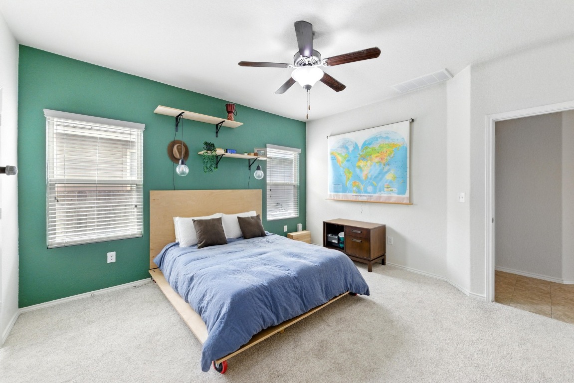 3905 Alpine Autumn Drive Austin, TX 78744 - Photo 9 of 24 Carpeted bedroom with visible vents, a ceiling fan, baseboards, and multiple windows
