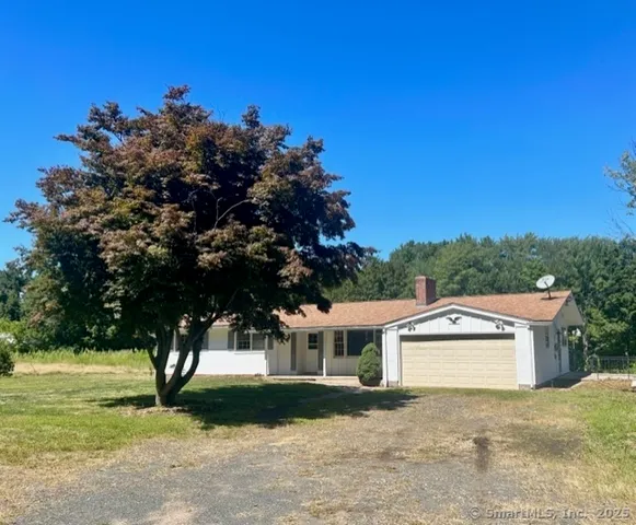 a front view of a house with a yard and trees