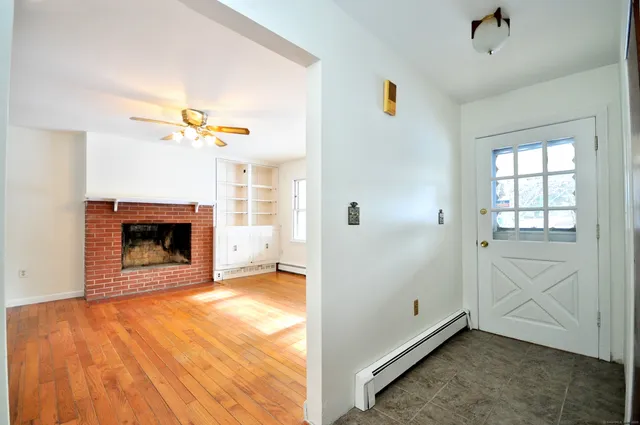 a view of an empty room with a fireplace and a window