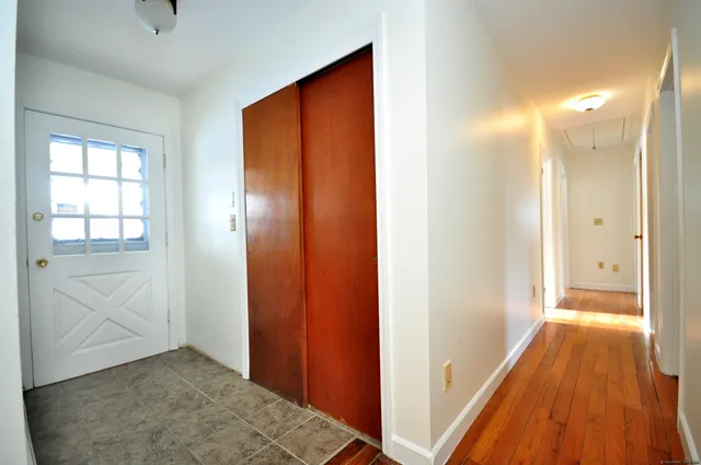 a view of a hallway with wooden floor and closet