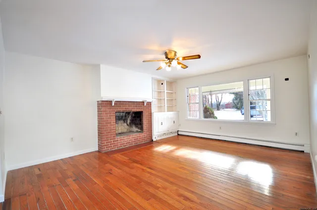 an empty room with a fireplace and windows