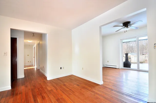 a view of empty room with wooden floor