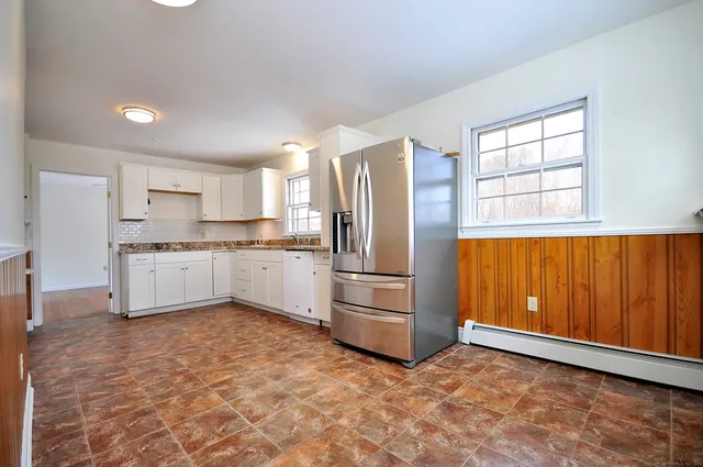 a kitchen with a refrigerator a stove top oven and cabinets